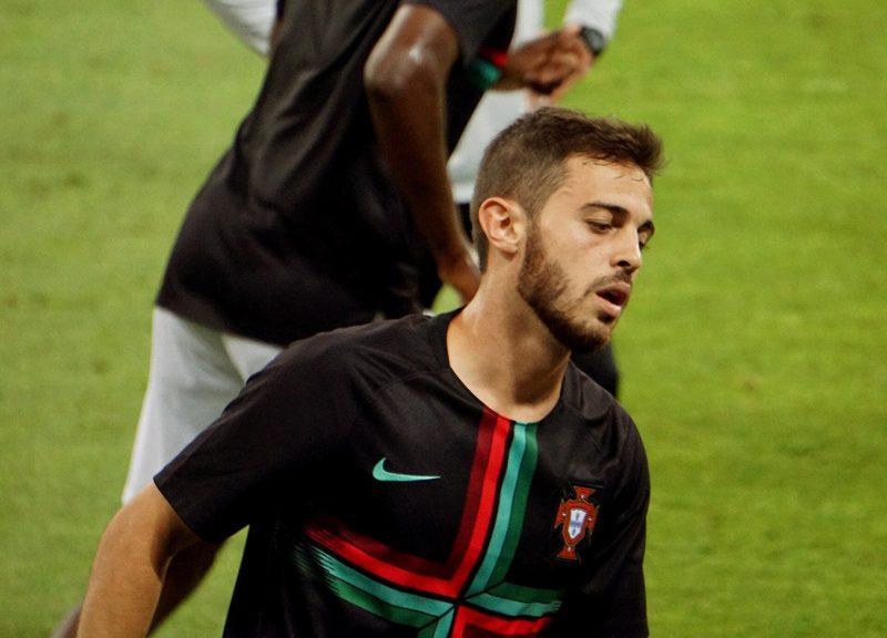 Bernardo Silva de barba, com o equipamento de treino preto da seleção portuguesa, num relvado