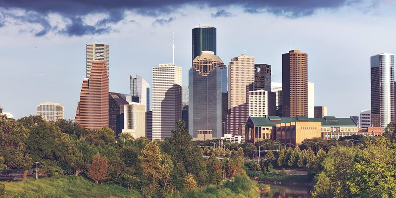 The downtown Houston skyline behind trees along Buffalo Bayou