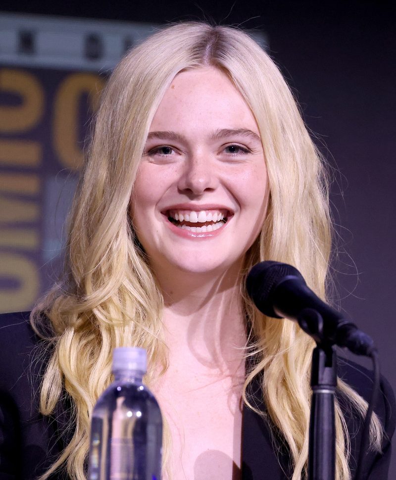 Elle Fanning smiling at a microphone while speaking at the 2025 San Diego Comic-Con
