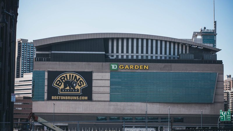 The exterior of TD Garden in Boston with a large Boston Bruins banner on its facade